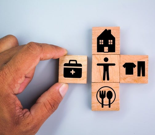 A hand holding a wooden block with icons on it